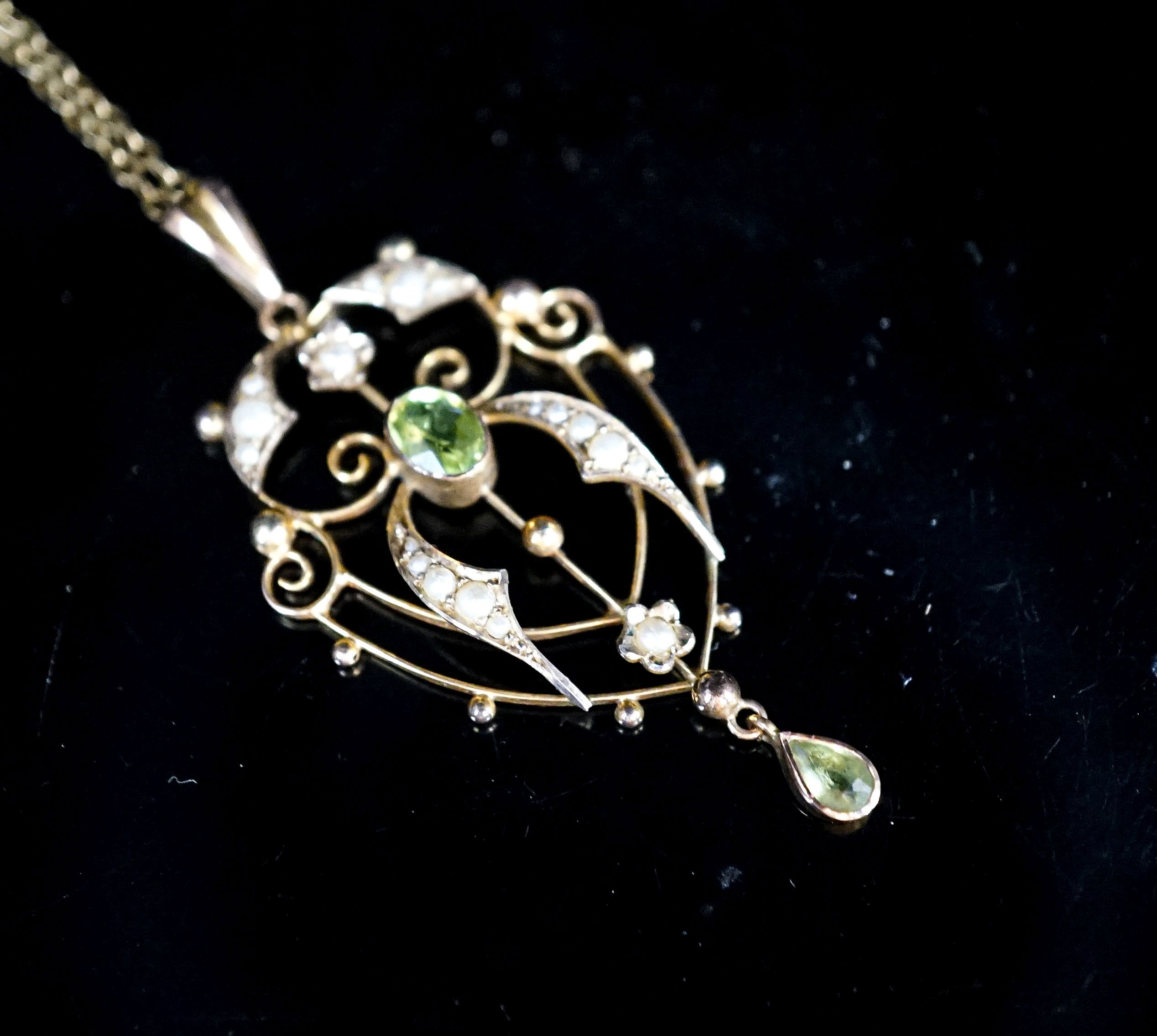 An Edwardian 9ct, peridot and seed pearl set drop pendant, 42mm, on a 9ct chain, 49cm